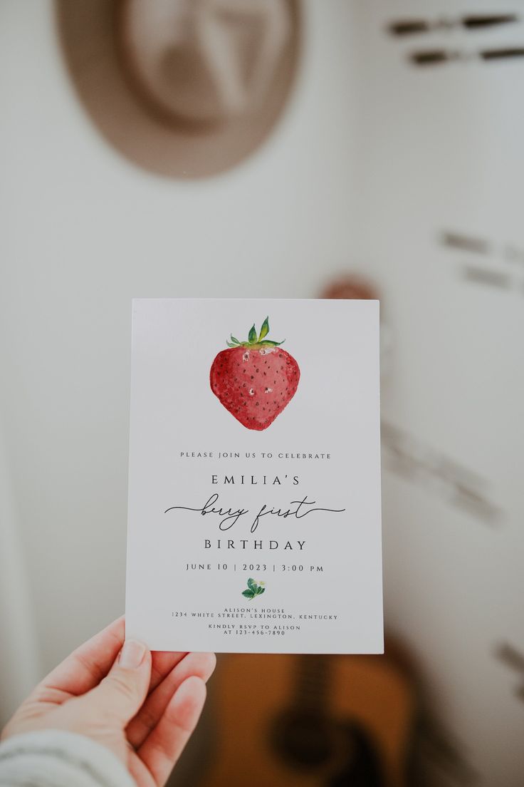 a person holding up a card with a strawberry on it