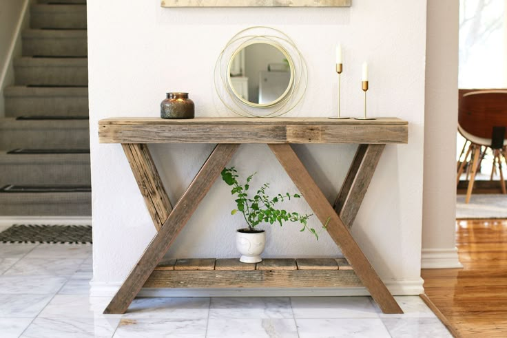 a wooden table with a potted plant on it in front of a stair case