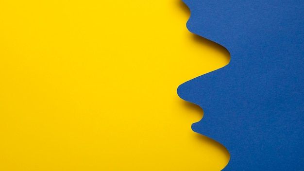 two blue and yellow abstract shapes against a bright yellow background with copy space in the middle