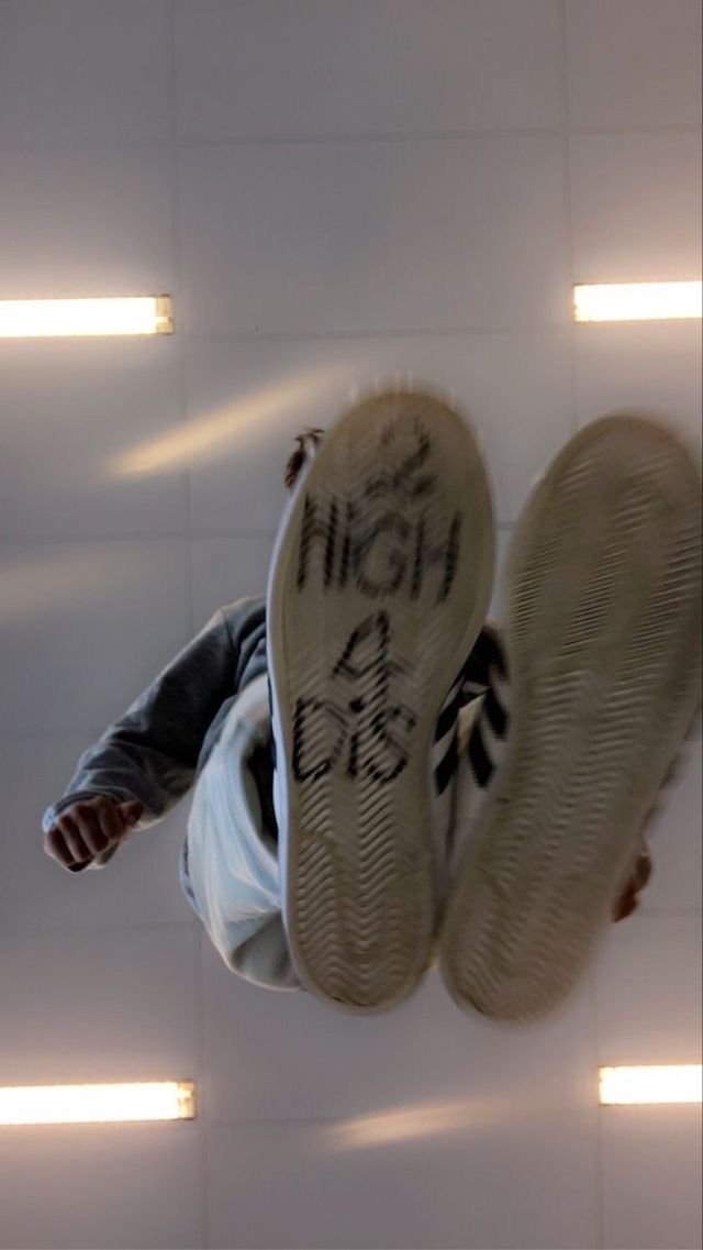 a person upside down on the ground with their feet in the air and writing on them