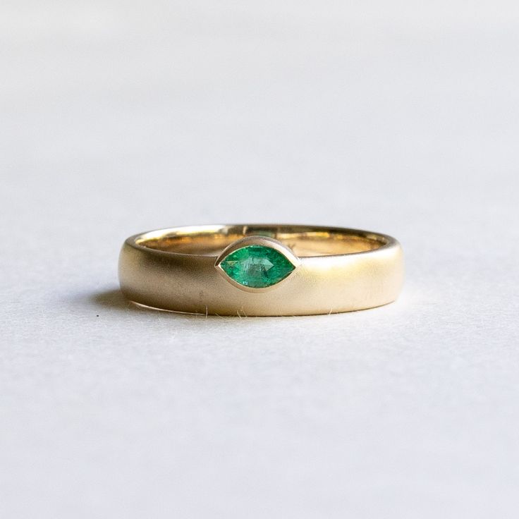 Off set emerald marquise band Metal: 14k yellow gold Stone: Natural emerald Stone Shape: Marquise Stone Size: 3x5 mm Finish: Matte Dimension: Approx 4mm band width Available in yellow, rose and white gold upon request Classic Gold Marquise Emerald Ring, Classic Marquise Emerald Ring In Gold, Gold Marquise Emerald Ring In 14k Gold, Heirloom Marquise Emerald Ring, Yellow Gold Marquise Jewelry With Bezel Setting, Stackable Marquise Yellow Gold Jewelry, Heirloom Gold Marquise Cut Emerald Ring, Heirloom Marquise Cut Gold Emerald Ring, Marquise Emerald Ring In Gold