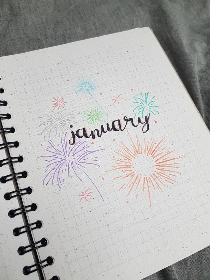 an open notebook with the word january written on it and fireworks in the sky above