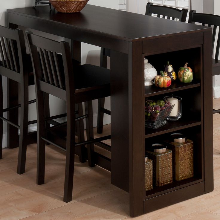 a kitchen table with two chairs and a shelf filled with fruits and vegetables on it