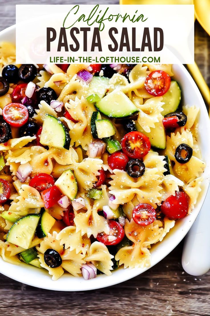 pasta salad with cucumbers, tomatoes, and olives in a white bowl