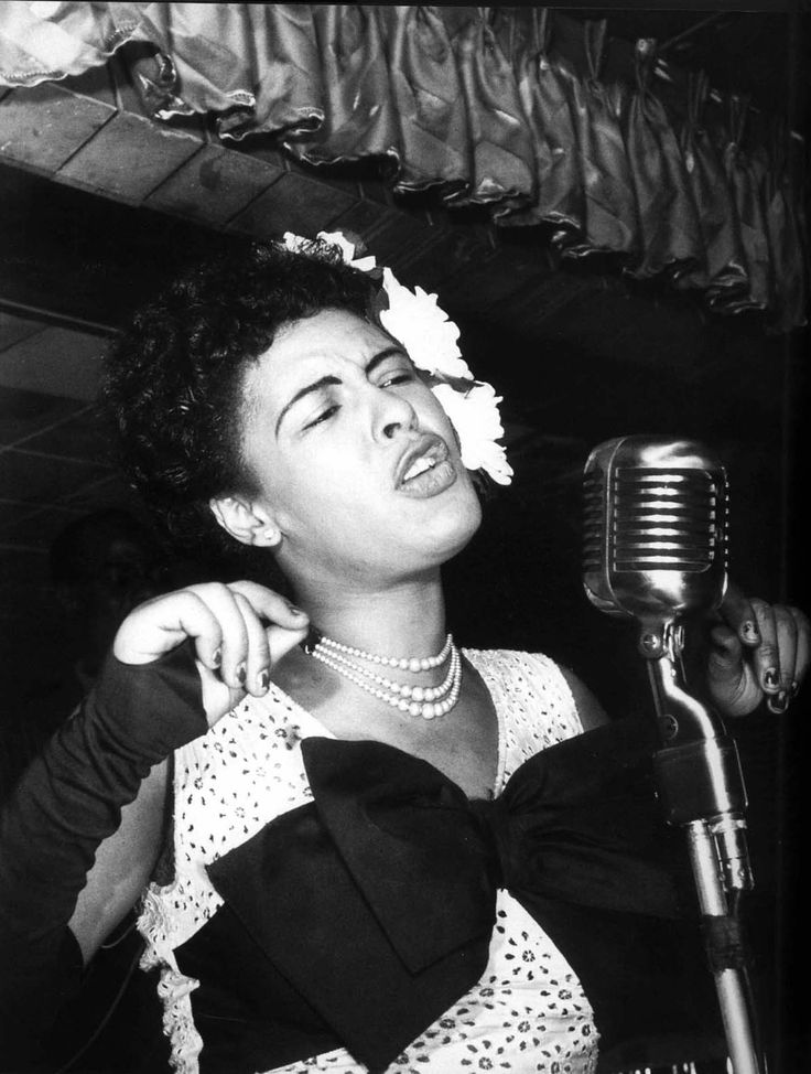 an old photo of a woman singing into a microphone