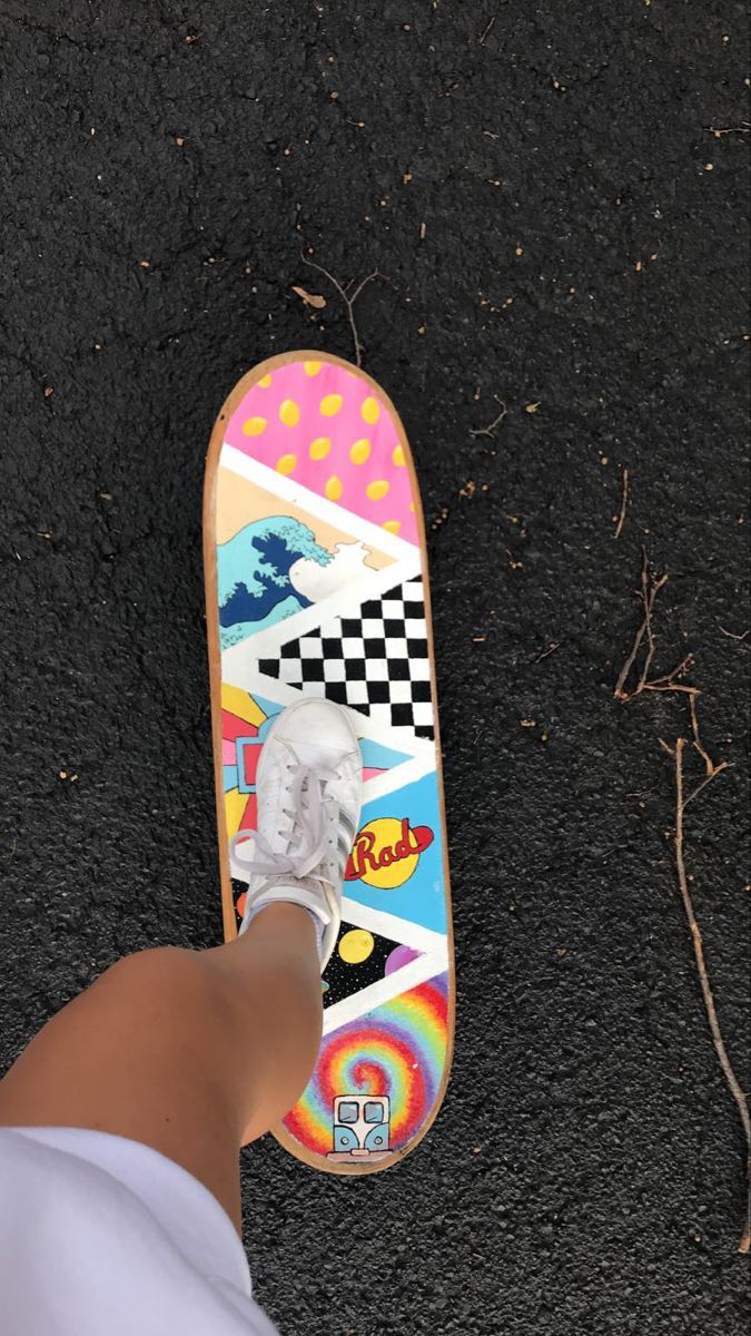 a person standing next to a skateboard on the ground