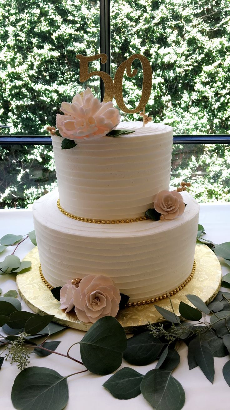 a three tiered white cake with flowers on top