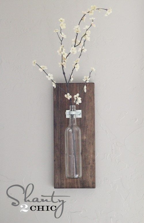 a vase with flowers in it is hanging on the wall next to a sign that says start chic