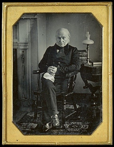 an old black and white photo of a man sitting in a chair