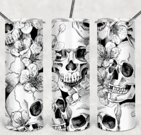 three cans with skulls and flowers on them, one has a straw in the middle