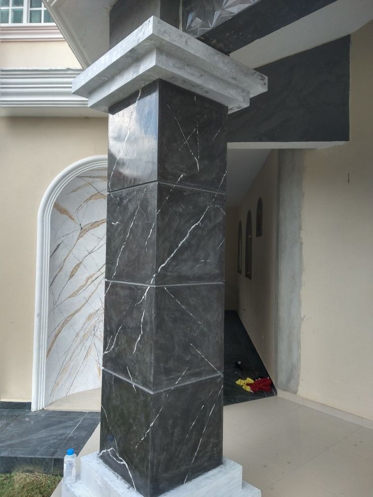 a black and white marble column in front of a house