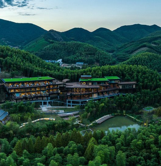 an aerial view of the resort surrounded by trees and mountains at night with lights on