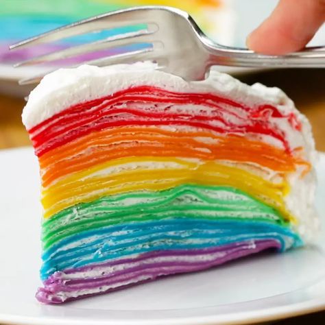 a slice of rainbow cake on a plate with a fork