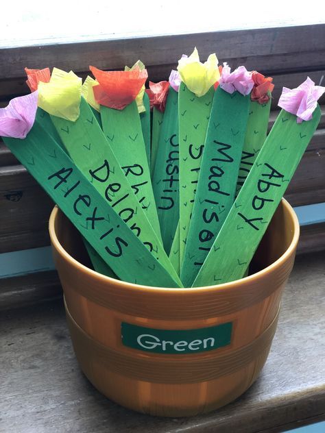 green paper flowers in a pot with writing on them