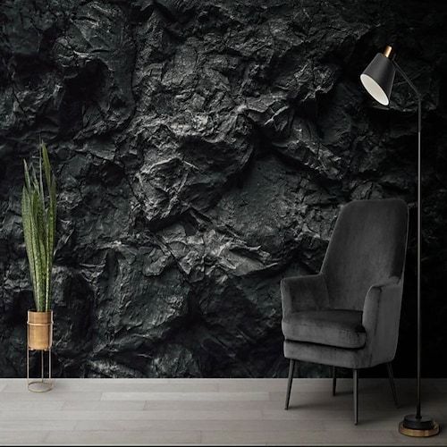 a black stone wallpaper with a chair and lamp next to it in a living room