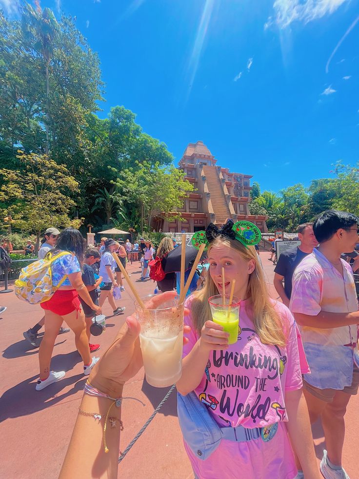 a group of people standing around each other with drinks in their hands and straws sticking out of their mouths