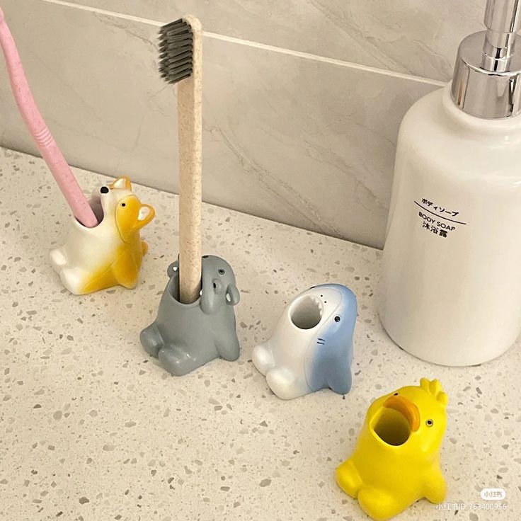 three toothbrush holders sitting next to each other on a bathroom counter