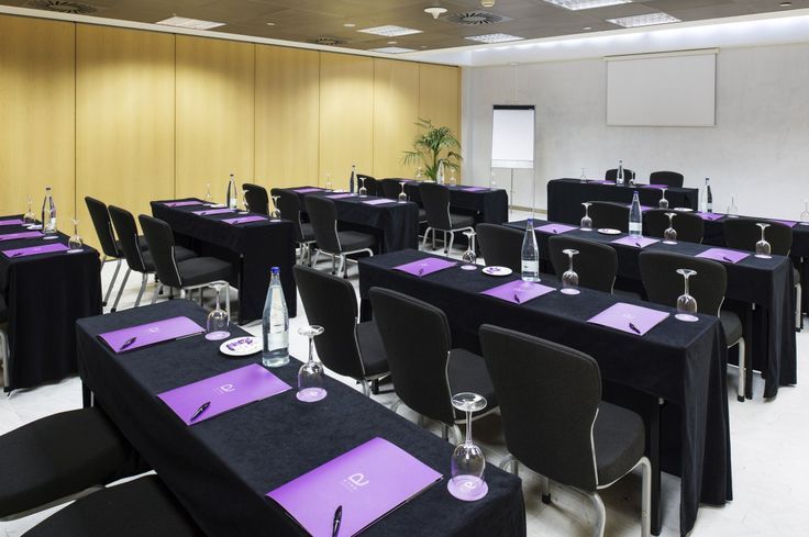 an empty conference room set up with purple and black table cloths on the tables