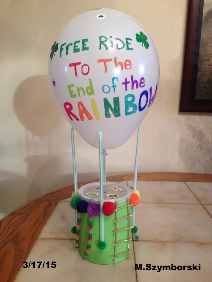 a white balloon sitting on top of a green container with writing on it and two sticks sticking out of it