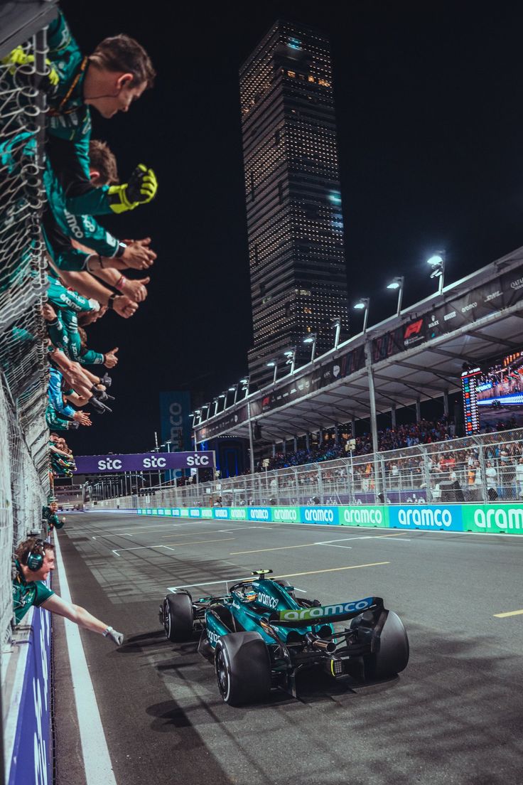 a man standing next to a race car on top of a track