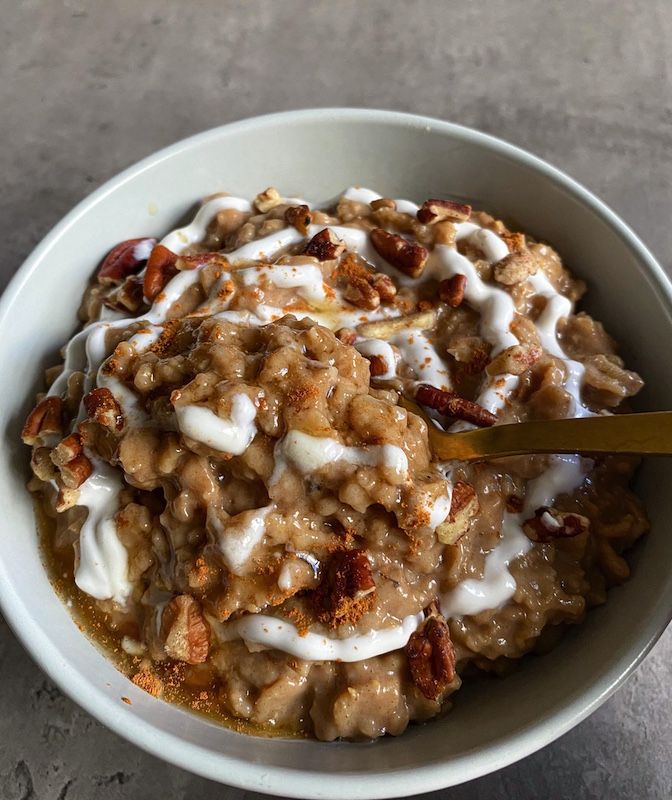 a white bowl filled with oatmeal and nuts on top of a table