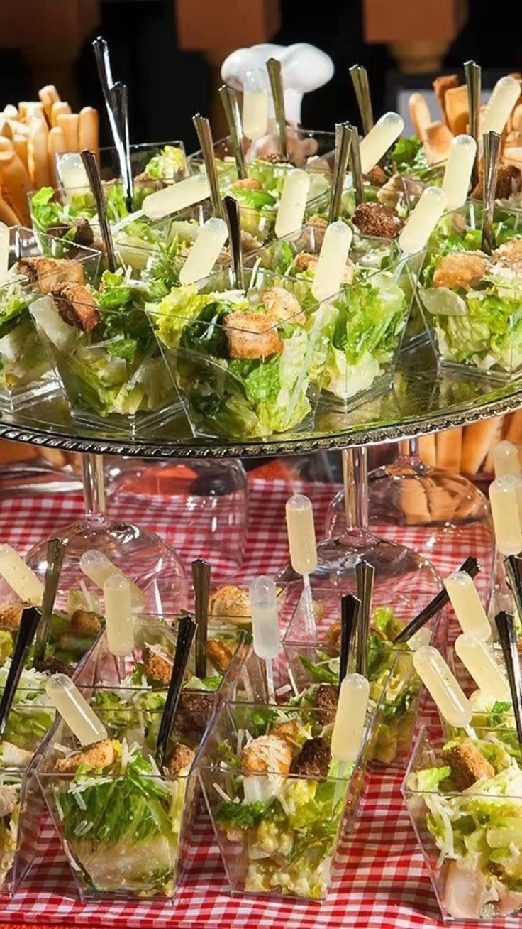 several trays filled with different types of food on top of a checkered table cloth