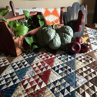 a table topped with vegetables and fruit on top of a quilt