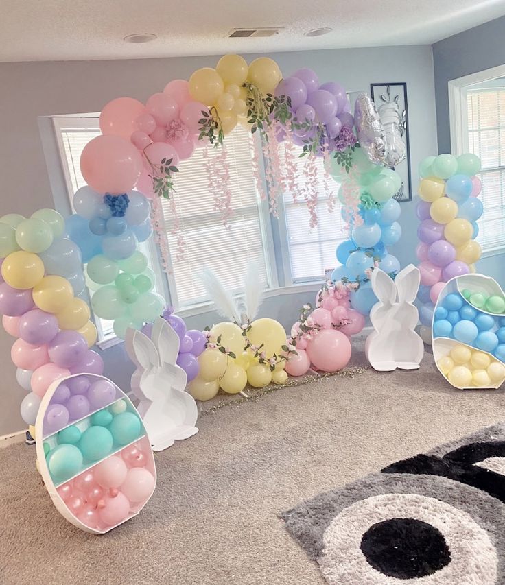 a room decorated with balloons and bunnies in pastel colors, including bunny ears