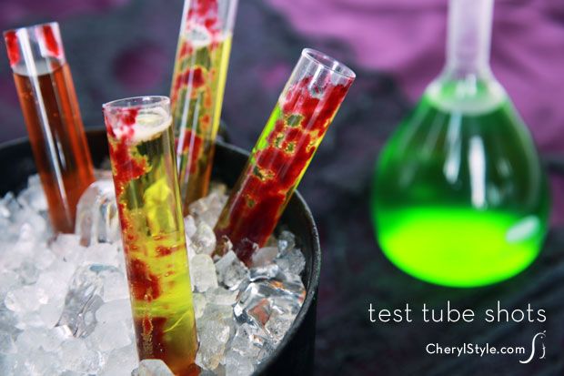 four test tubes in a bowl filled with ice and liquid next to a green flask