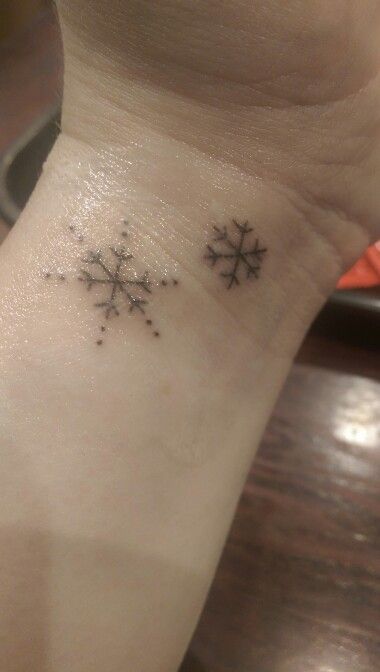 a small snowflake tattoo on the wrist and foot is shown in black ink