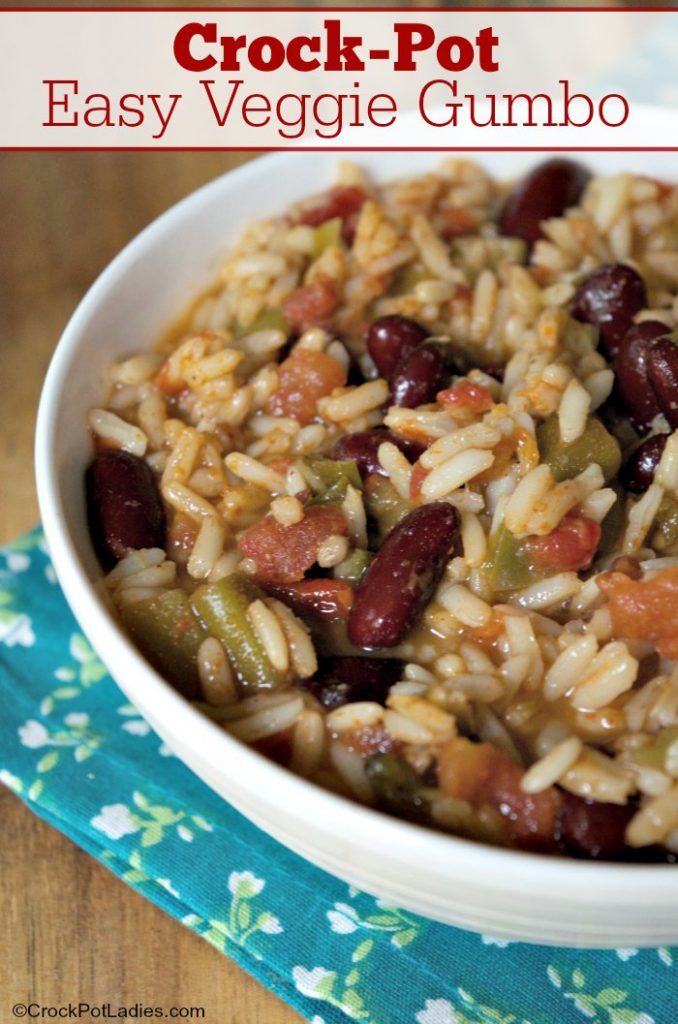 a white bowl filled with rice and beans on top of a blue napkin next to a wooden table