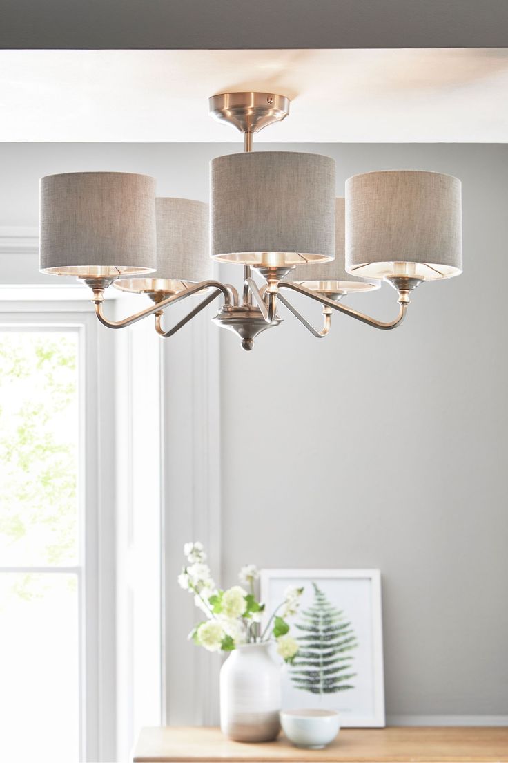 a chandelier hanging from the ceiling in a room with white walls and windows