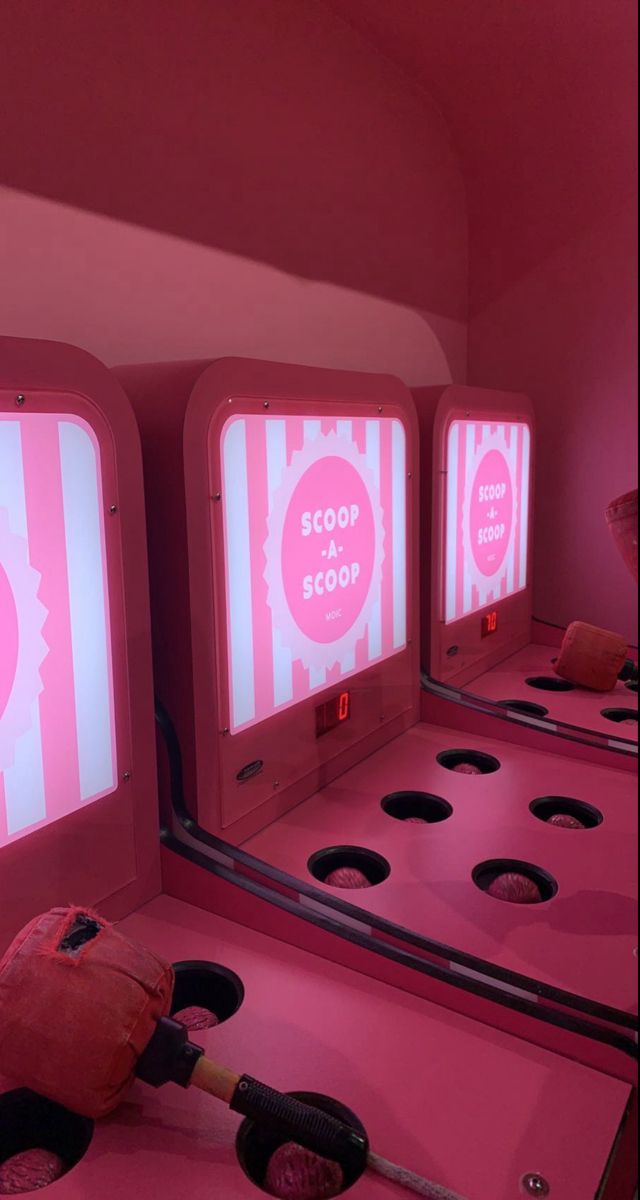 a pink room with three machines that are lit up