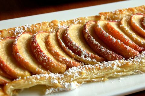 some kind of pastry on a plate with powdered sugar around the edges and toppings