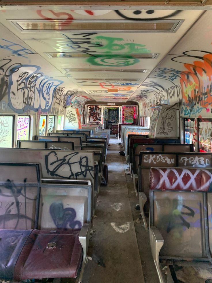 an empty bus with graffiti all over it's walls and ceiling, as seen from the inside