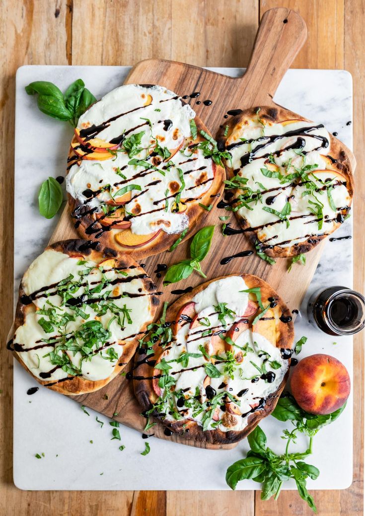 grilled peaches with basil and mozzarella on a cutting board