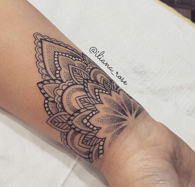 a woman's arm with a tattoo on it that has an intricate flower design