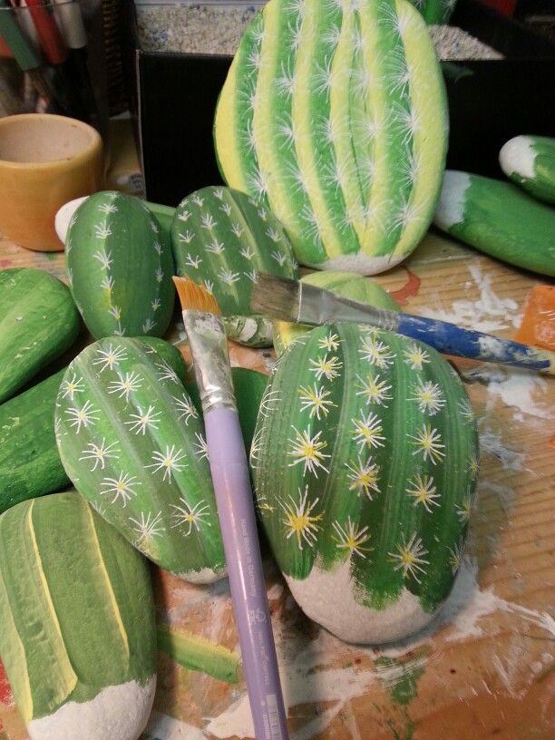 a table topped with lots of green cactus plants and watermelon cut up to look like they have been painted