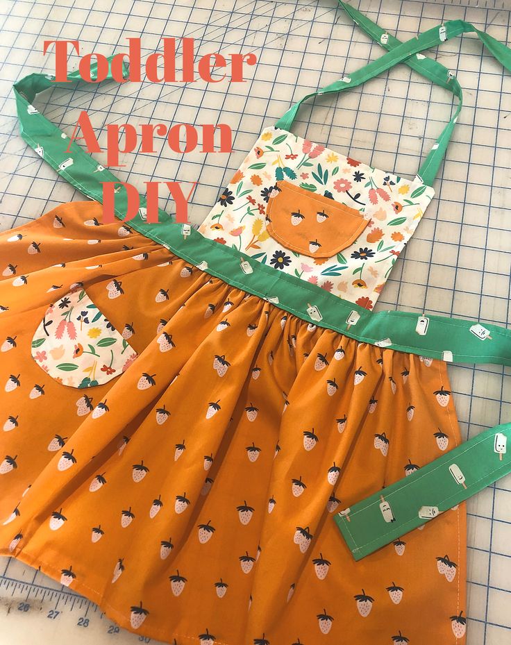 the apron is made out of an orange and green dress with apples on it, as well as other pieces of clothing