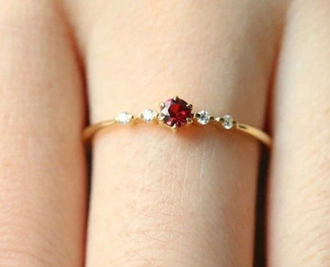 Copper based with 18k gold plating. Gold Dainty Ruby Ring For Formal Occasions, Dainty Gold Ruby Ring For Formal Occasions, Red Crystal Party Ring, Elegant Red Crystal Ring For Party, Fine Jewelry Gold Crystal Ring With Ruby, Dainty Red Diamond Ring, Dainty Gold Ruby Rings, Elegant Gold Crystal Ring With Ruby, Elegant Birthstone Ring