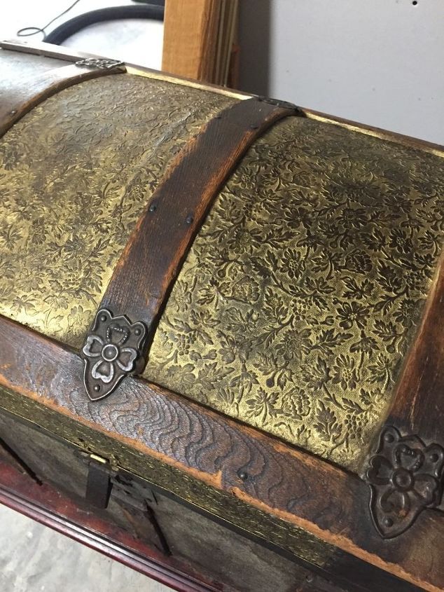 an old wooden trunk with gold and brown designs