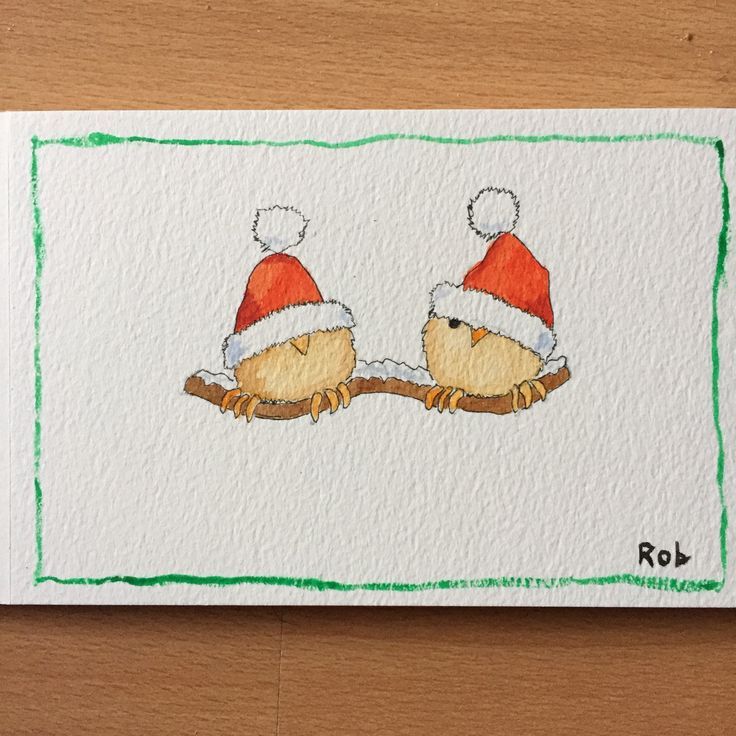 two birds wearing santa hats sitting on top of a piece of paper with green trim