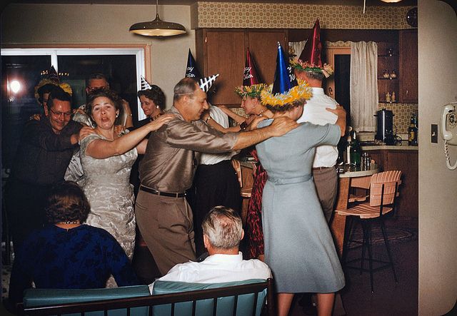 a group of people standing around each other in a room with hats on their heads