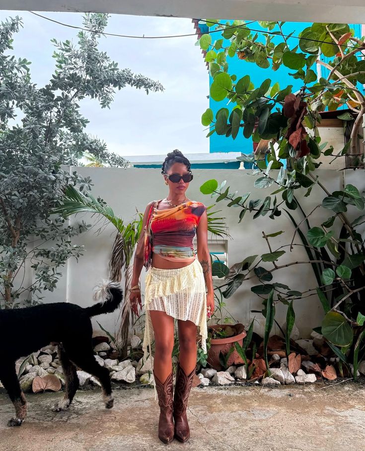 a woman standing next to a black dog