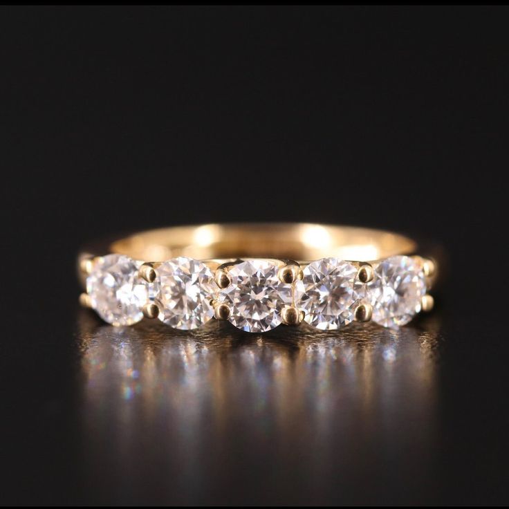 three stone diamond ring in yellow gold with diamonds on each side and the middle band