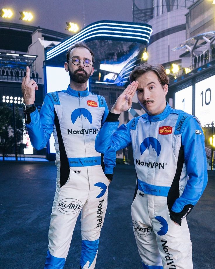 two people standing next to each other in racing suits