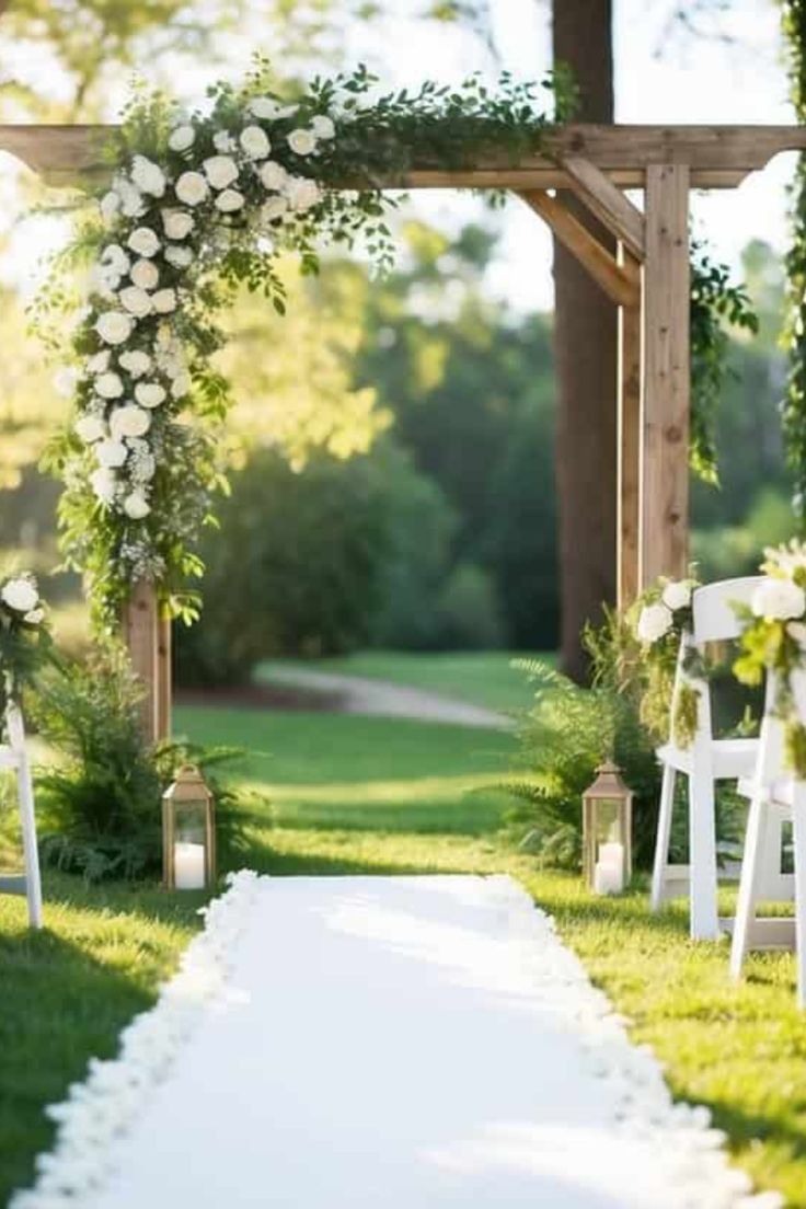 an outdoor ceremony with white flowers and greenery