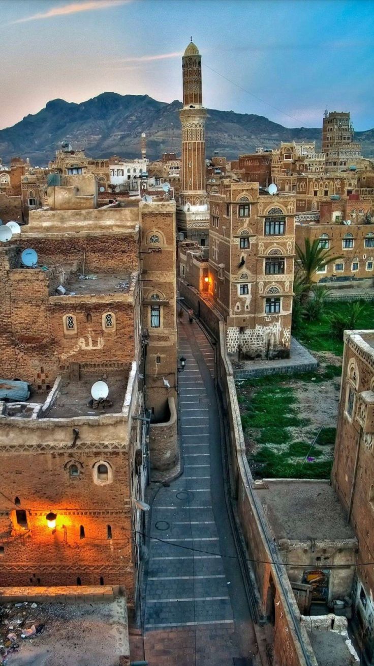 an aerial view of the old city at dusk, with mountains in the back ground