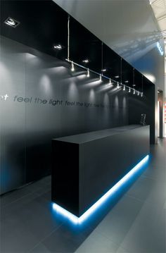 an office lobby with black and white walls, blue lights on the wall and floor