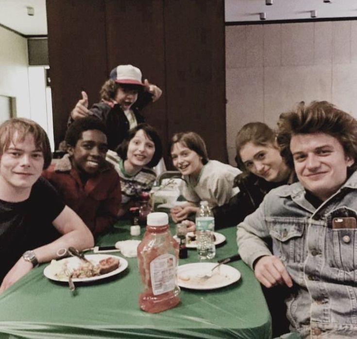 a group of people sitting around a table with plates of food in front of them